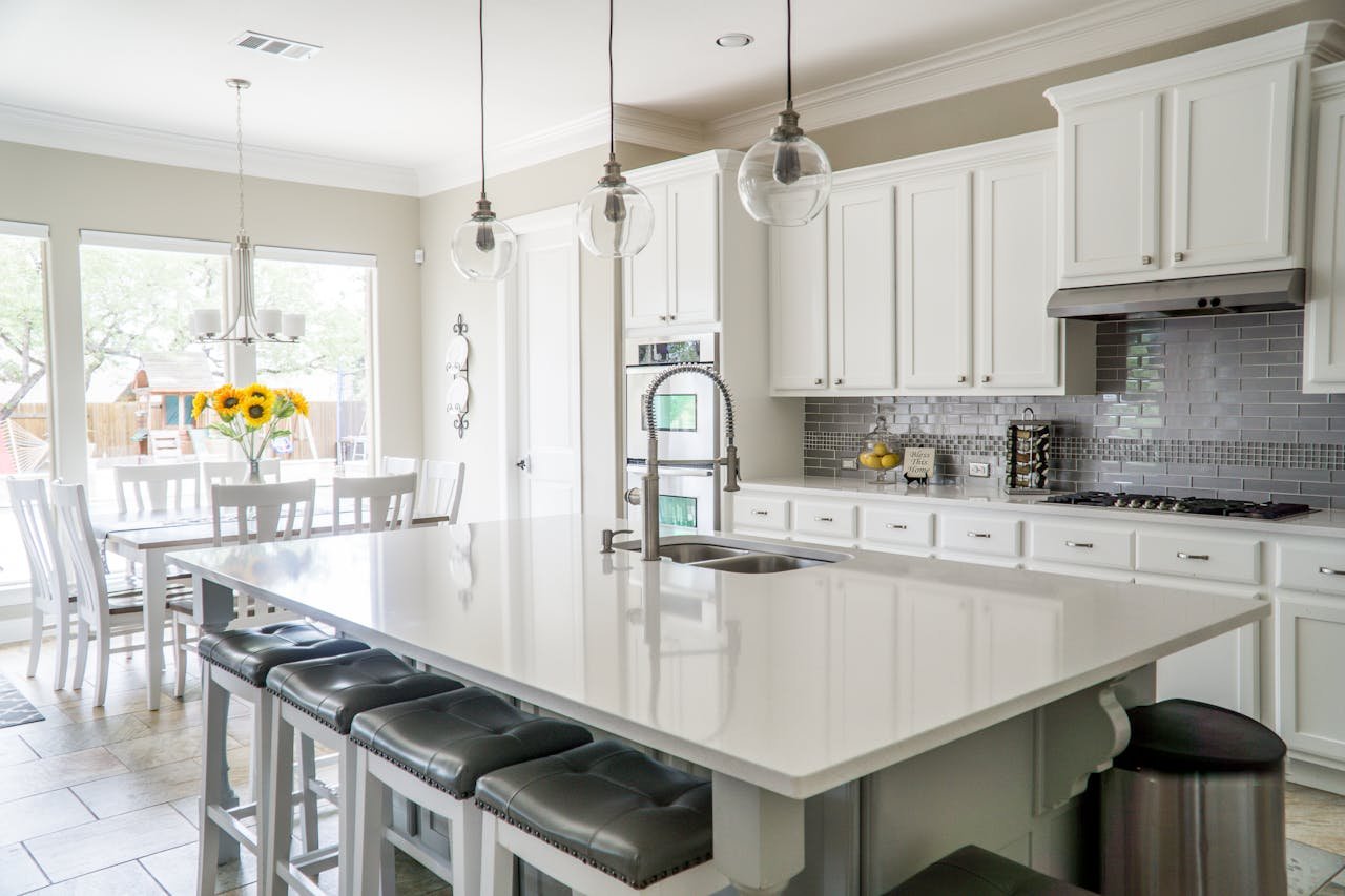 creative Spacious modern kitchen with white cabinets and island in natural light.