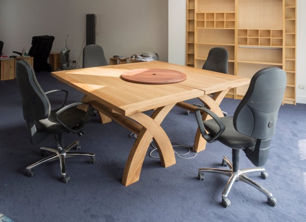 Contemporary office meeting room featuring a unique wooden table design and ergonomic chairs.